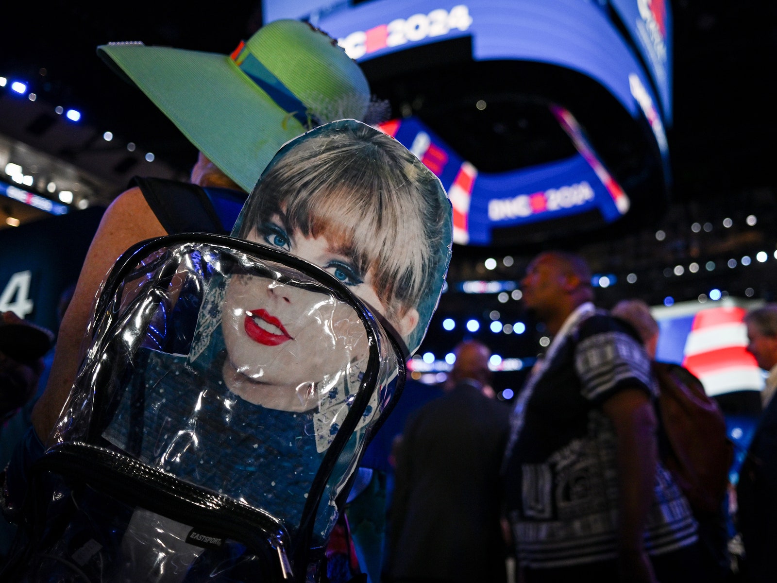 A person holding a poster of Taylor swift at the DNC.